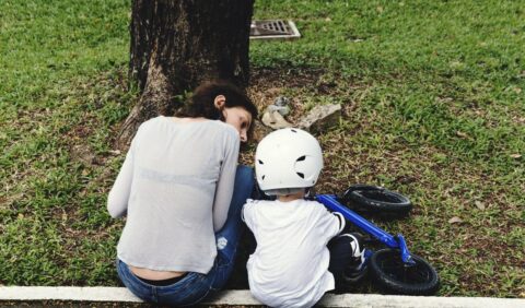 Parent helping teach their child how to ride a bike