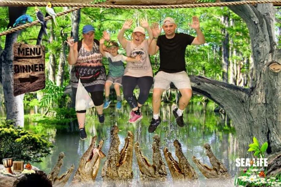 The Hart family having fun at an adventure park in a picture with fake crocodiles