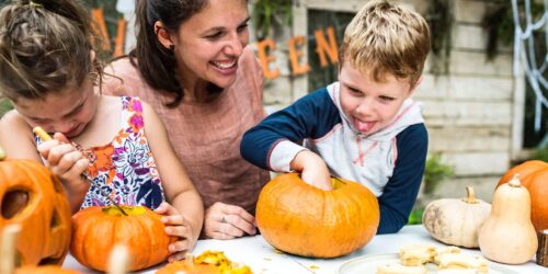 Mother and children carving pumpkins