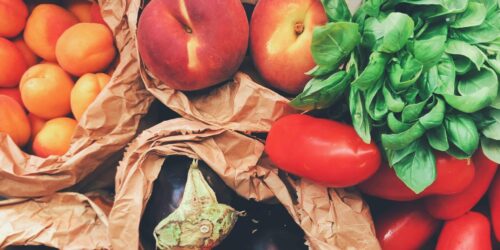 Various fresh fruits and vegetables in paper bags
