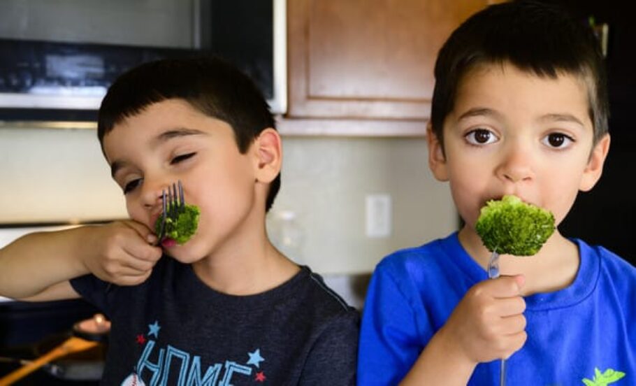 Boys eat broccoli
