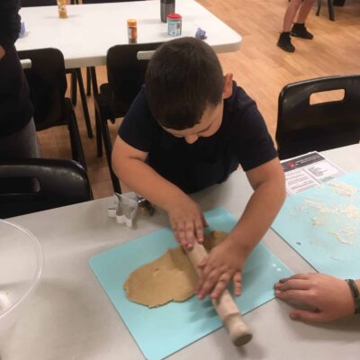 Child rolling out dough with a rolling pin