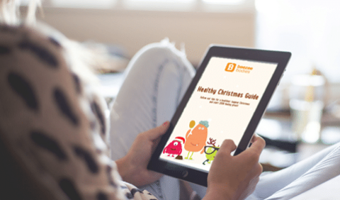 Person holding a tablet with the healthy beezee christmas guide