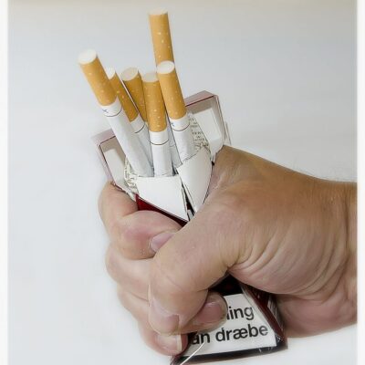 A man crushing a packet of cigarettes