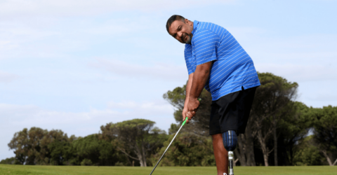 Overweight man with prosthetic leg playing golf