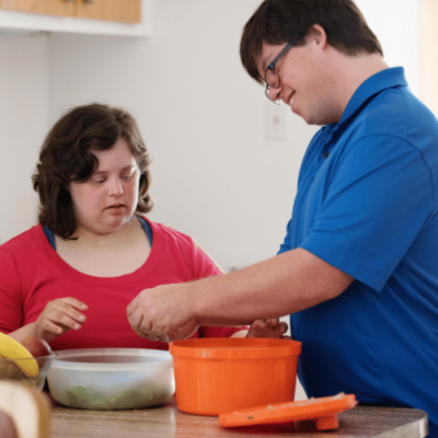 Two young people with learning disabilities preparing food
