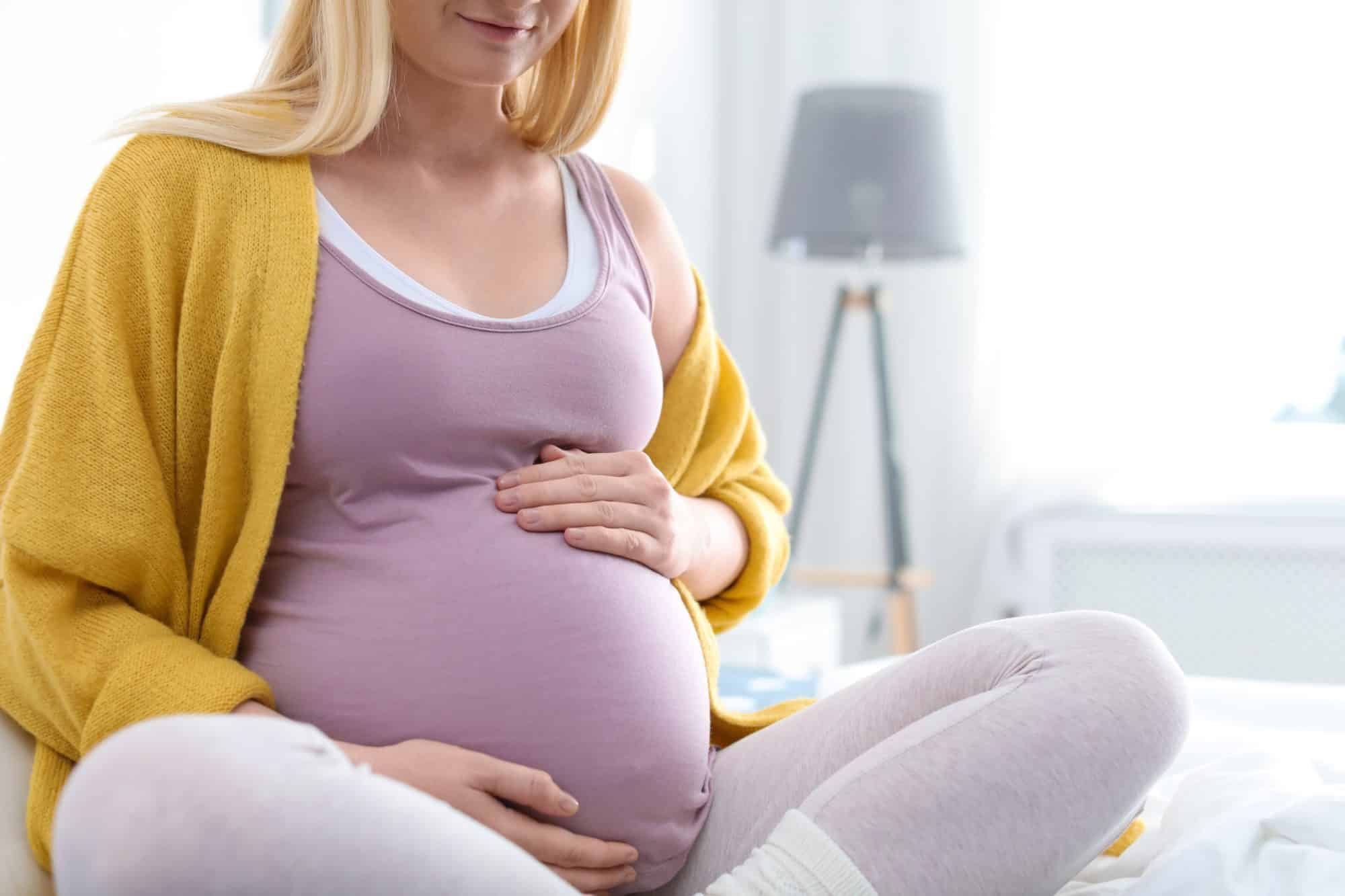 Heavily pregnant woman holding her bump