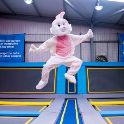 A person in an easter bunny costume jumping in a trampoline park