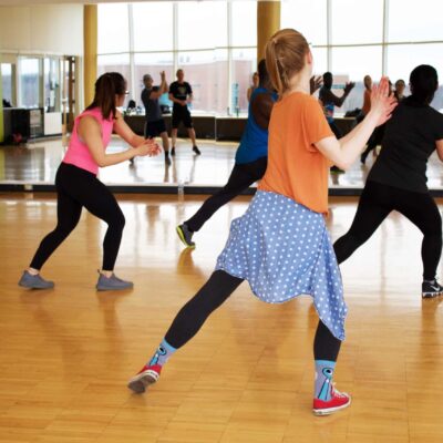 A group dance class in a gymnasium