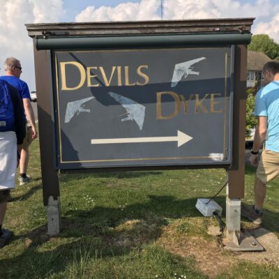 Group walking around a sign for Devil's Dyke
