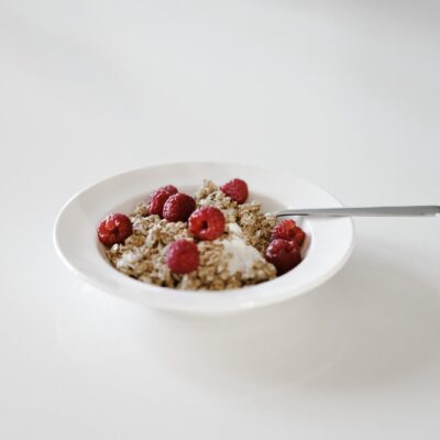 A bowl of cereal with raspberries