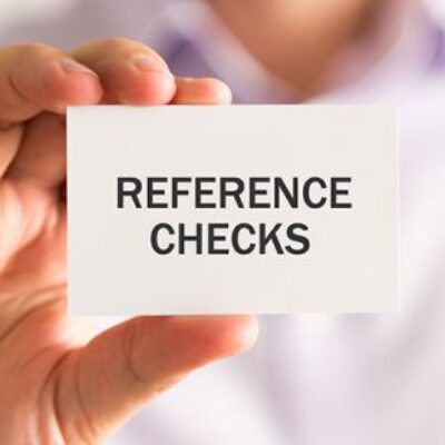 A person holding up a paper card that says 'Reference Checks'