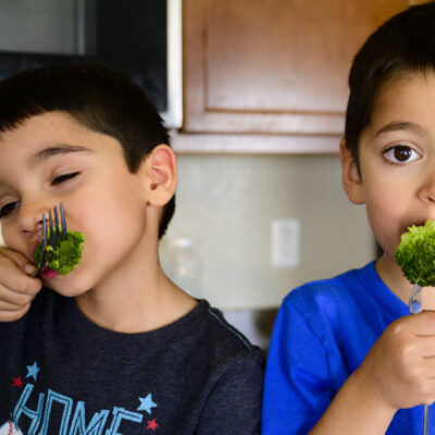 Boys eat broccoli for Obesity Awareness Month