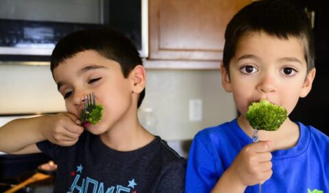 Boys eat broccoli for Obesity Awareness Month