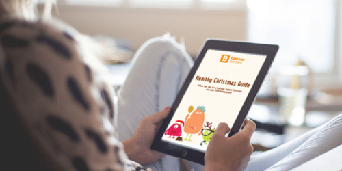Person holding a tablet with the healthy beezee christmas guide