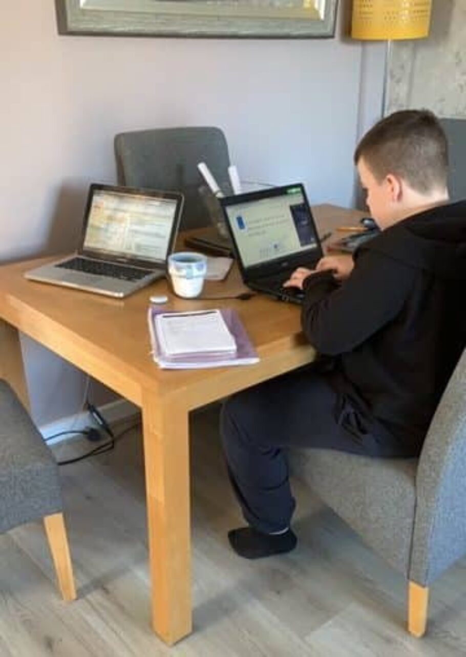 A boy logging into online school at the table