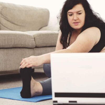 Overweight woman practicing yoga at home