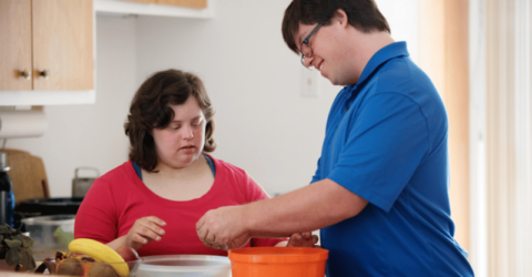 Two young people with learning disabilities preparing food