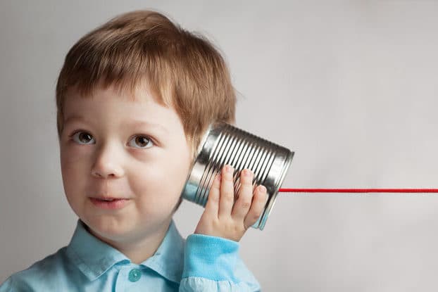 Young boy listening to a string telephone